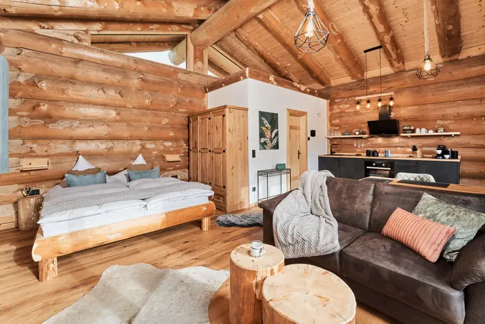 Offener Wohn- und Schlafbereich mit Doppelbett und Sofa